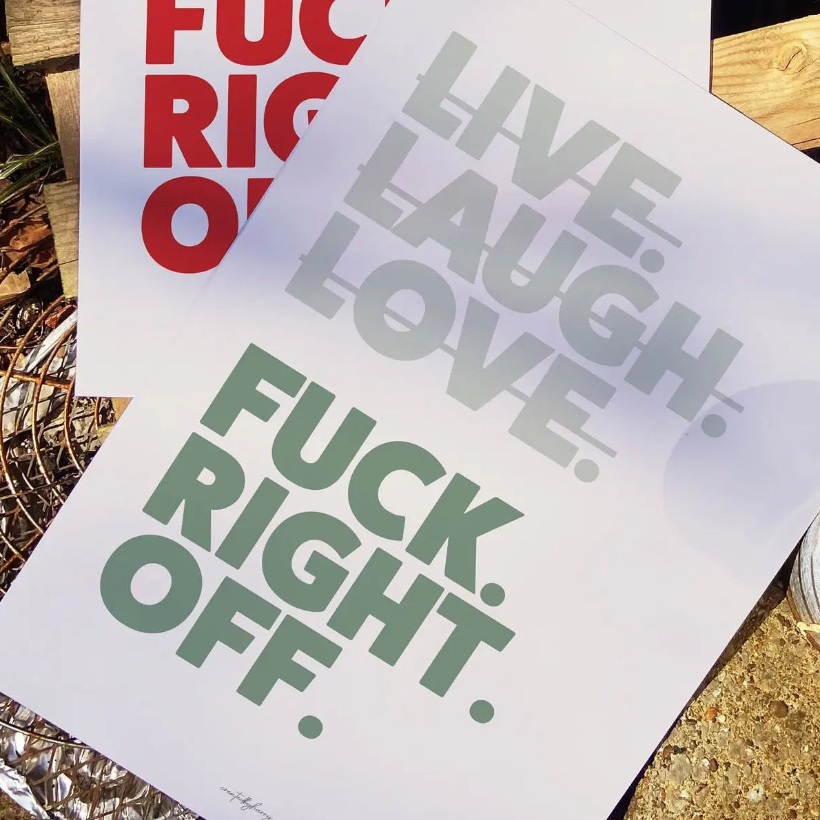 Two posters with motivational phrases on a wooden surface.