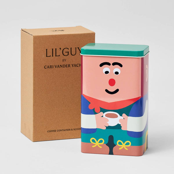 Coffee container with cartoon character design next to a brown box labeled 'LIL' GUY by Cari Vander Yacht'.