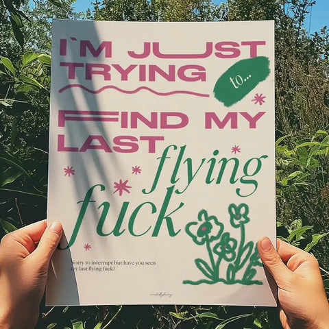 Person holding a poster with text and illustrations against a natural background