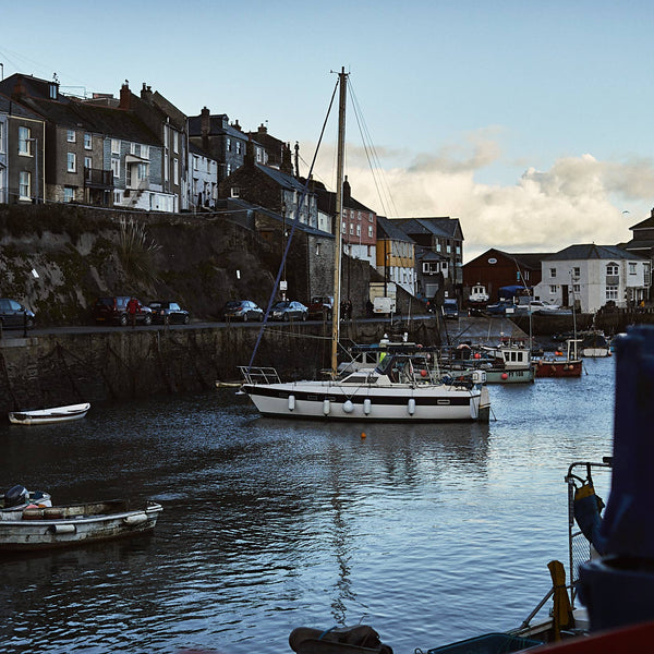 Harbor scene with boats and buildings in the evening.