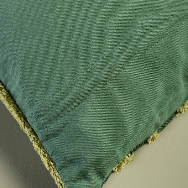 Green fabric with textured edge on a neutral background
