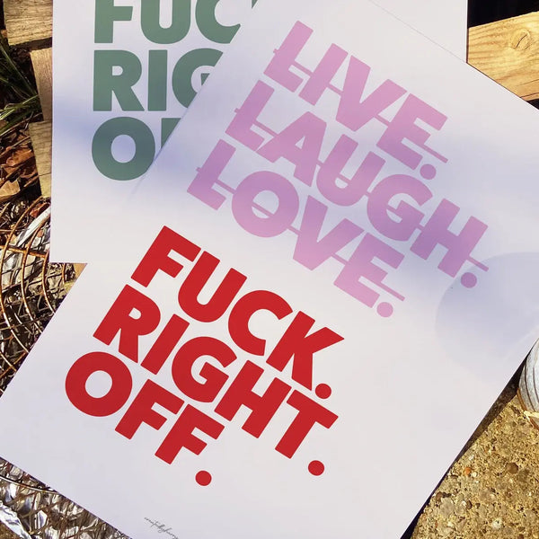 Two printed posters with motivational phrases on a wooden surface.
