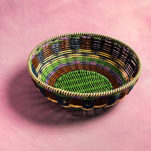 Woven basket with multicolored pattern on a pink background