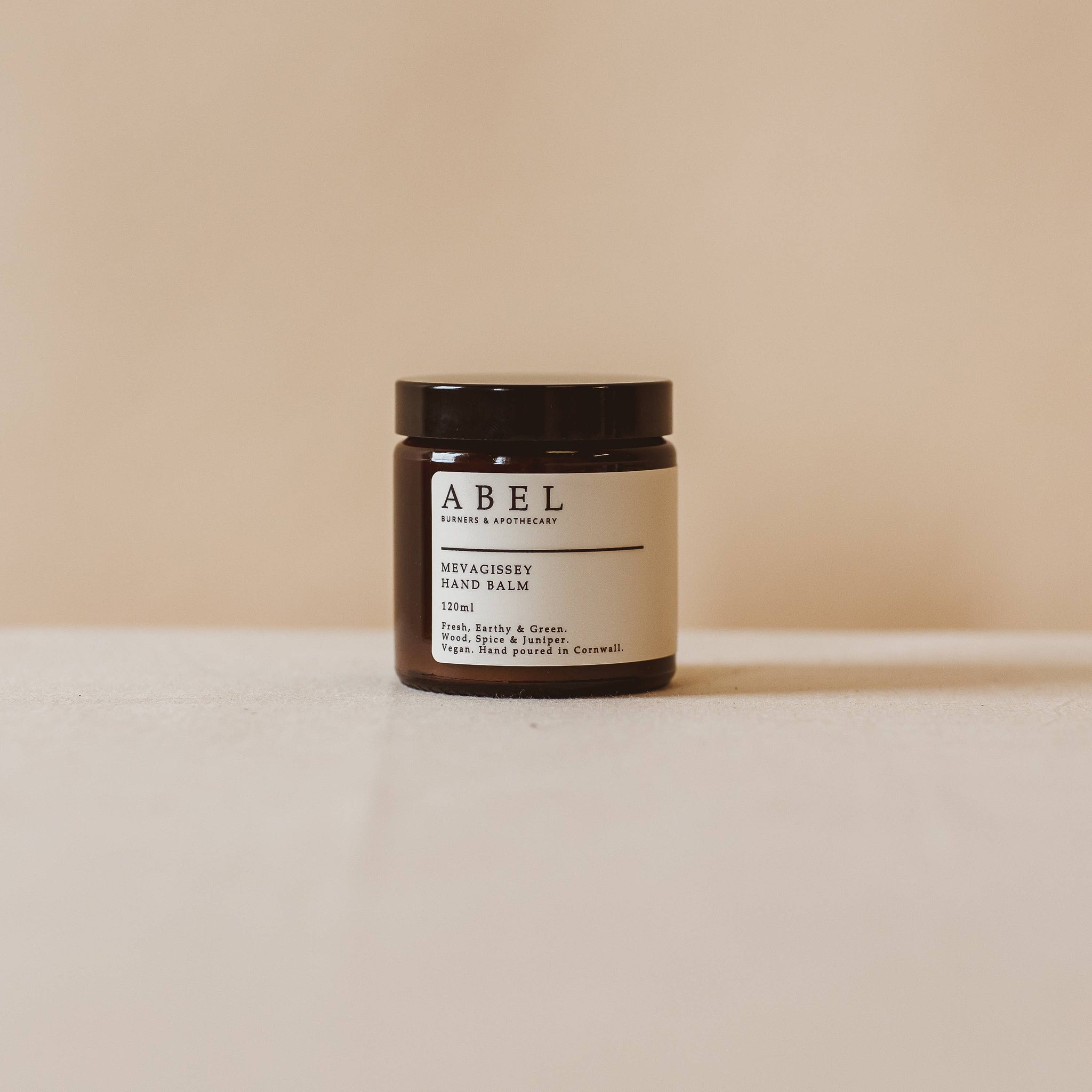 Jar of cream with a label on a beige background