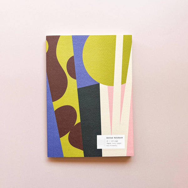 Colorful notebook with abstract design on a light pink background