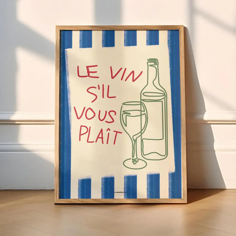Framed artwork with a blue and white striped border, red text, and a bottle and glass illustration on a light wooden floor.
