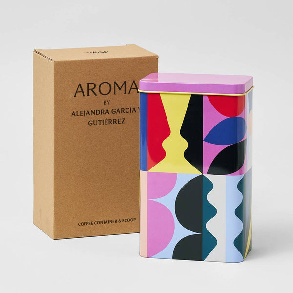 Colorful coffee container with geometric design next to a brown box labeled 'AROMA by Alejandra Garcia Gutierrez'.