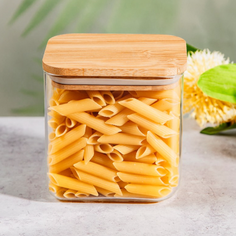 A clear glass storage jar with a bamboo lid.